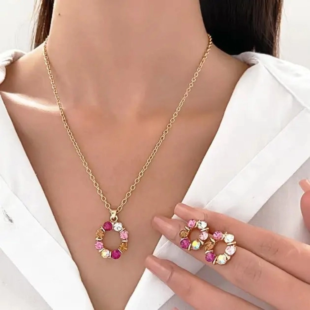 Gold-tone circle pendant set with pink, amber and clear stones, shown with matching stud earrings