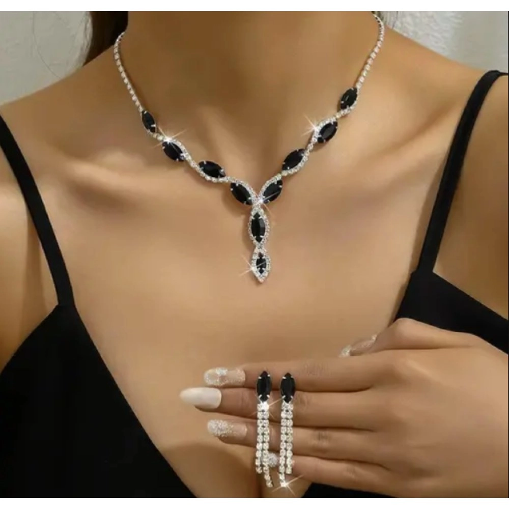 Model wearing a black stone necklace with a pendant drop and matching black earrings