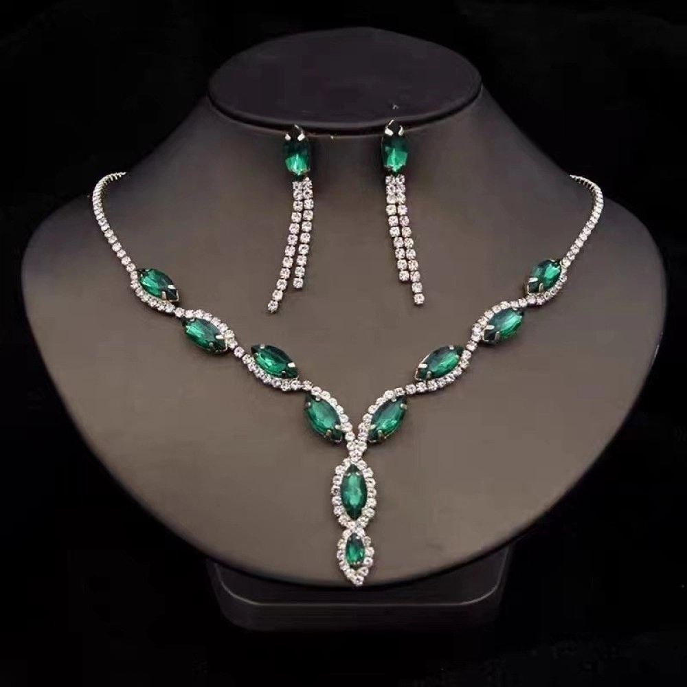 Green marquise-cut stone necklace and long tassel earrings displayed on a bust
